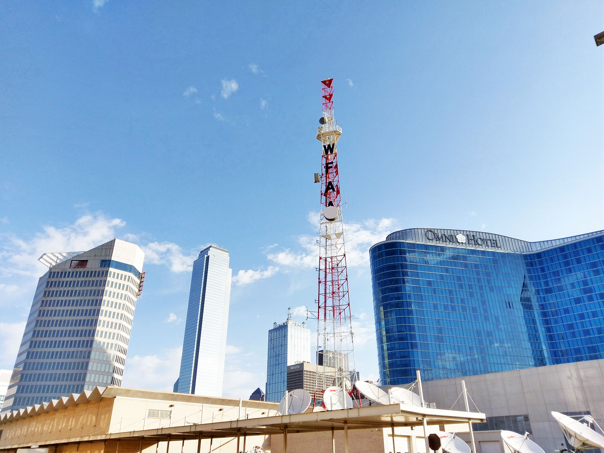 The view from the parking lot of The Dallas Morning News, including WFAA, the Omni Hotel, and Bank of America Plaza.