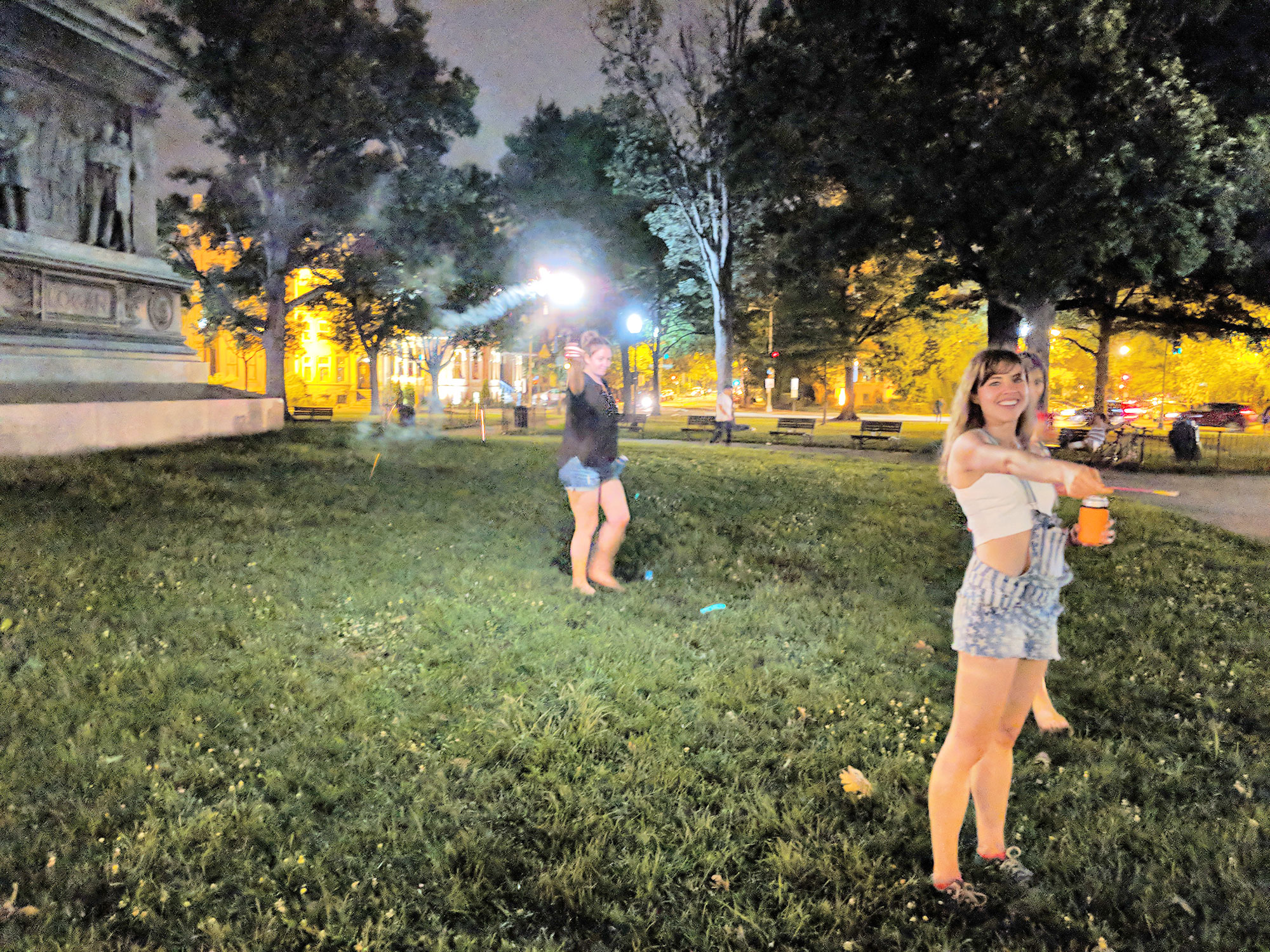 Women lighting fireworks in Logan Circle, Washington D.C.