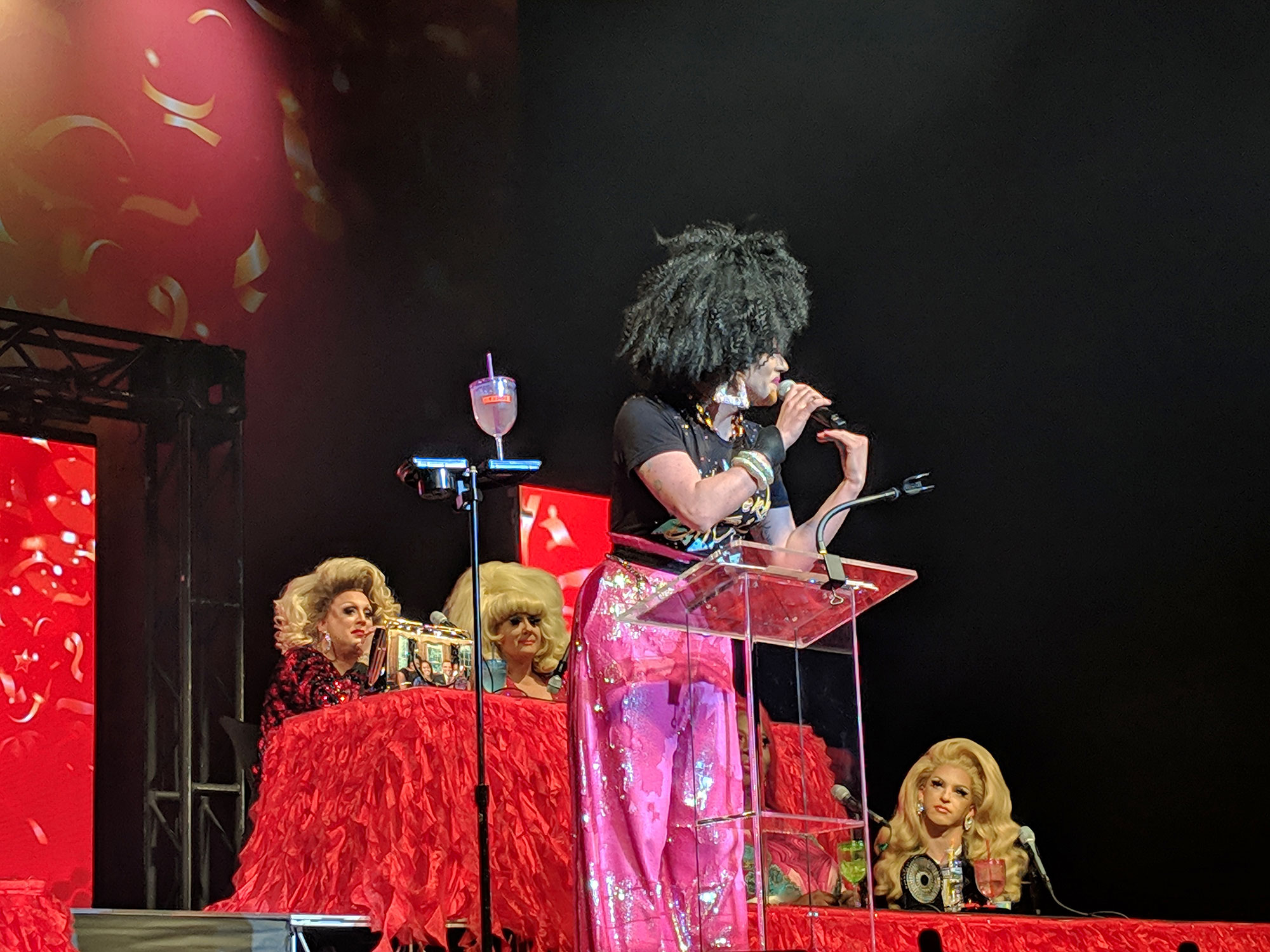 Thorgy Thor performing at the Warner Theatre in Washington D.C. with queens glaring in the background.