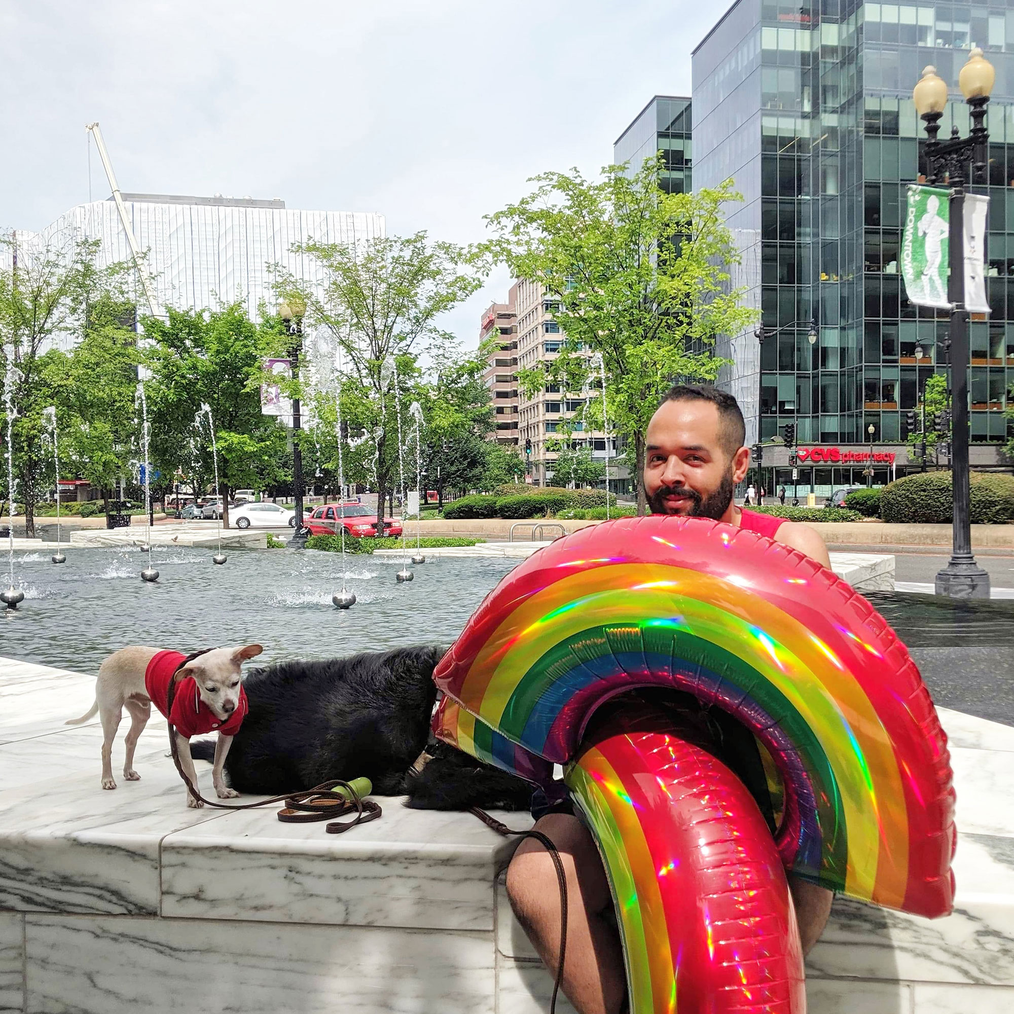 Dennis posing with the dogs and obnoxious rainbow balloons near Washington D.C.'s CityCenter.
