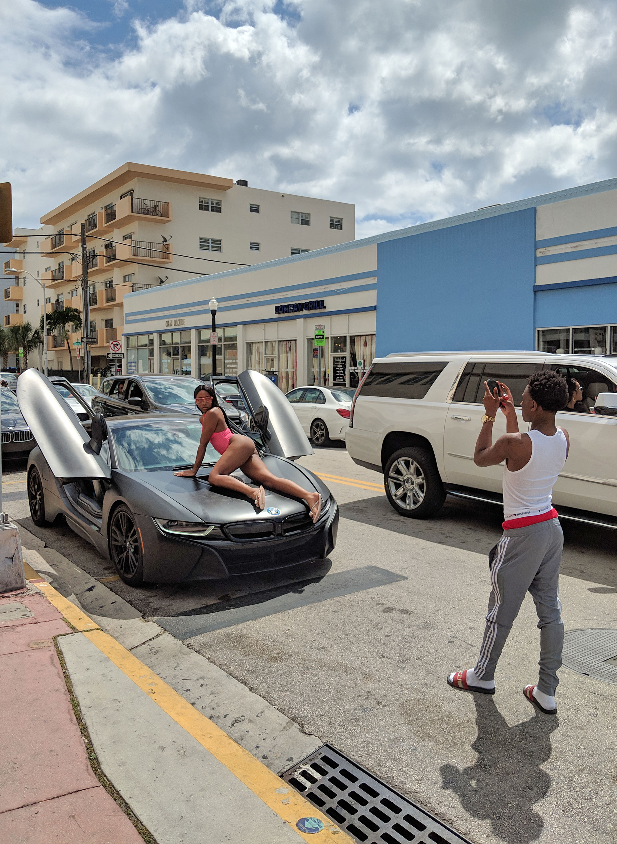 A woman posing on a car in front of a South Beach Starbucks.