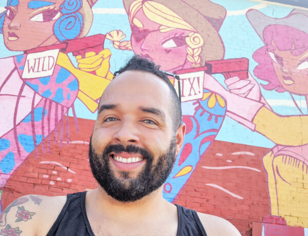 Dennis Jansen posing at a mural in Dallas, Texas.